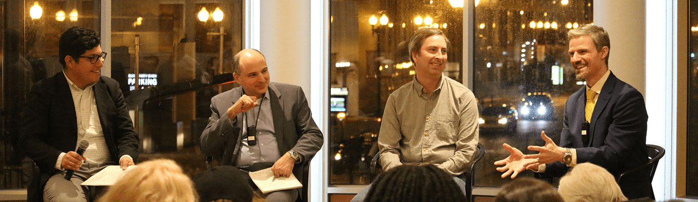 A group of four panelist present their ideas in front of an audience.