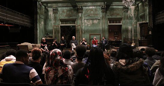 school faculty learning from production on stage