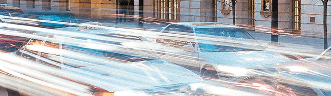 Cars blurred from the motion of driving past Goodman Theatre.