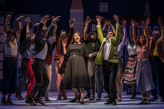 group of actors on stage singing