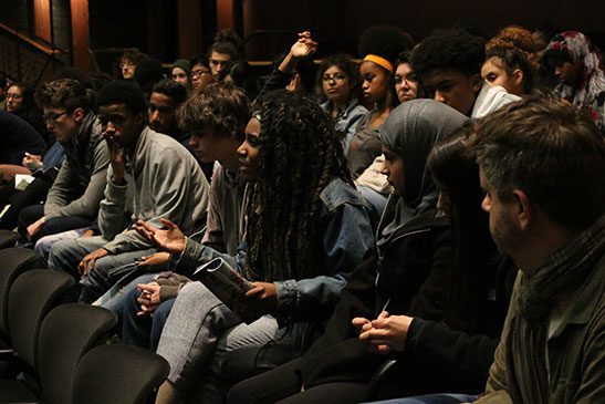 Students learning about theatre programs in an audience setting.