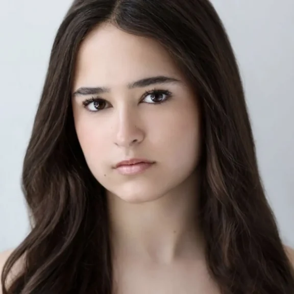 Headshot of a young woman with long dark hair looking directly at the camera.
