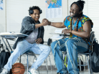 Two classmates do a handshake.