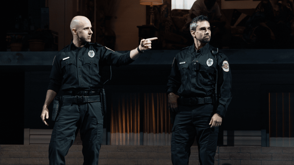 Two cops standing looking to their left, one is pointing a finger.