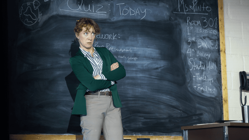Schoolteacher with arms crossed and a surprised expression.