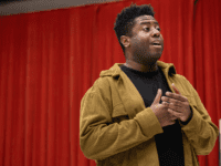 Juicy wears a black top and khaki jacket.