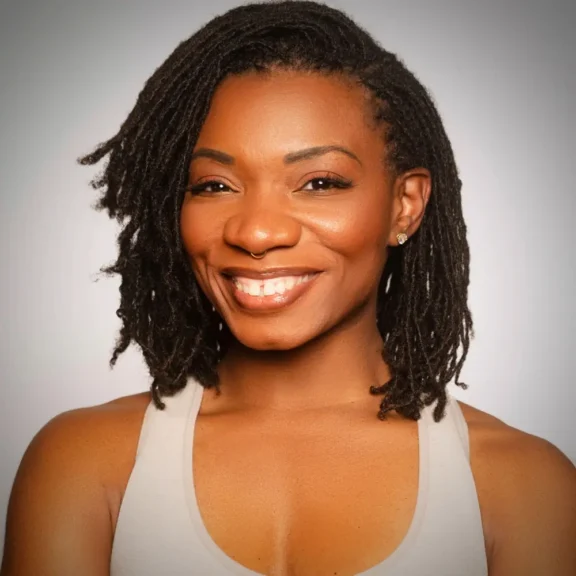 Woman with shoulder-length, twisted hair smiling and wearing a light-colored tank top against a plain, gradient background.