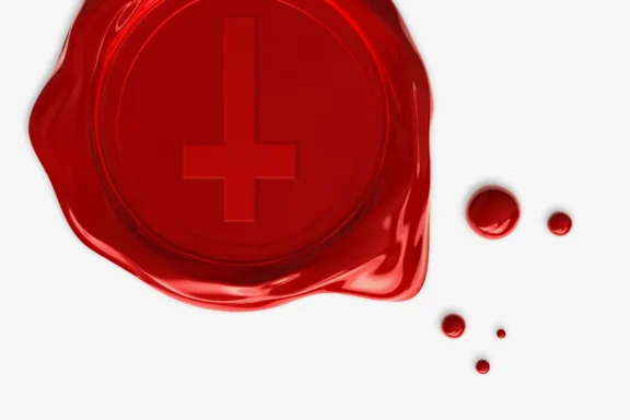 Red wax seal with an embossed upside-down cross, accompanied by several drops of red wax on a white background.