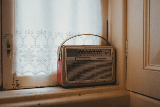 Red transistor radio on a windowsill.
