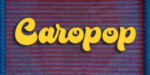 The word "Caropop" is written in bold, yellow cursive letters against a red and blue woven fabric background.