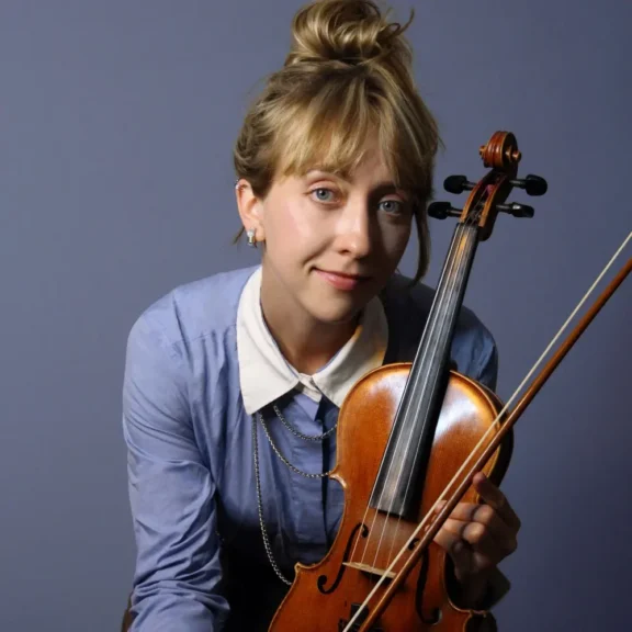 A woman holding a violin and bow.