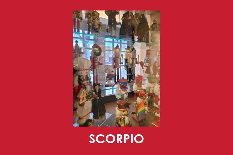 A glass display case filled with various nutcracker figurines; the word "SCORPIO" appears at the bottom of the image on a red background.