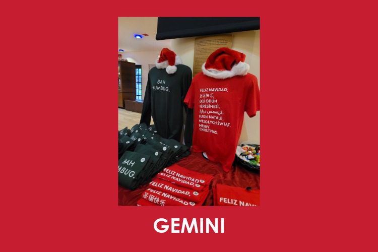 Display of holiday-themed t-shirts with Santa hats on top; one shirt says "BAH HUMBUG" and another says "FELIZ NAVIDAD" in multiple languages.