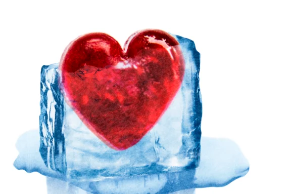 A red heart encased in a melting blue ice cube on a white background.