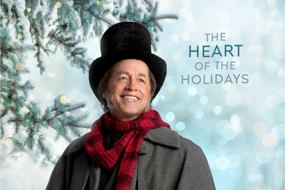 Smiling person in a top hat, red scarf, and gray coat stands near snowy pine branches with the text “The Heart of the Holidays” in the background.