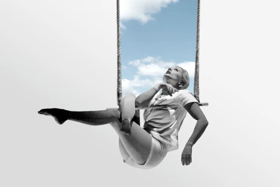 A person in casual clothing sits on a trapeze against a background of blue sky and clouds, looking upward with a contemplative expression.