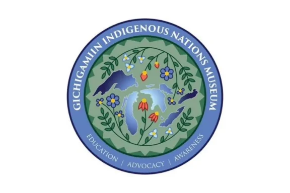 Circular logo for the Gichigamiin Indigenous Nations Museum, featuring a floral design with the Great Lakes and the words "Education | Advocacy | Awareness" on a blue border.