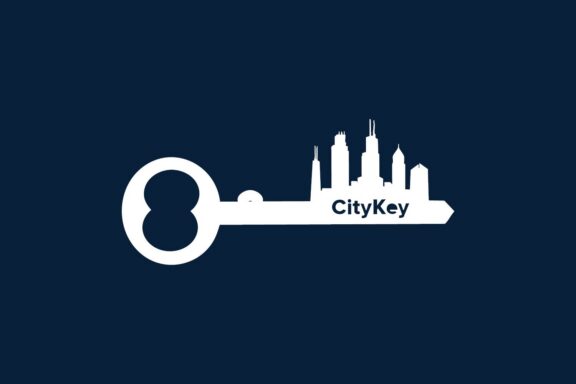A white key with city skyline silhouettes and the text “CityKey” on a dark blue background.