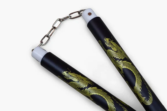 Black nunchucks connected by a silver chain, decorated with gold dragon illustrations.