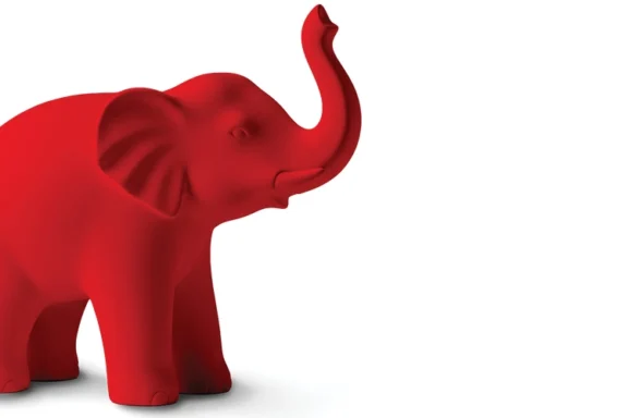 Bright red elephant sculpture with its trunk raised.
